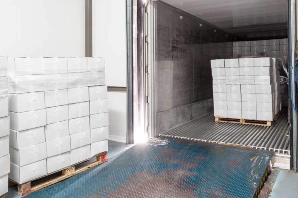 Packaged food cartons moving between refrigerated storage and a truck